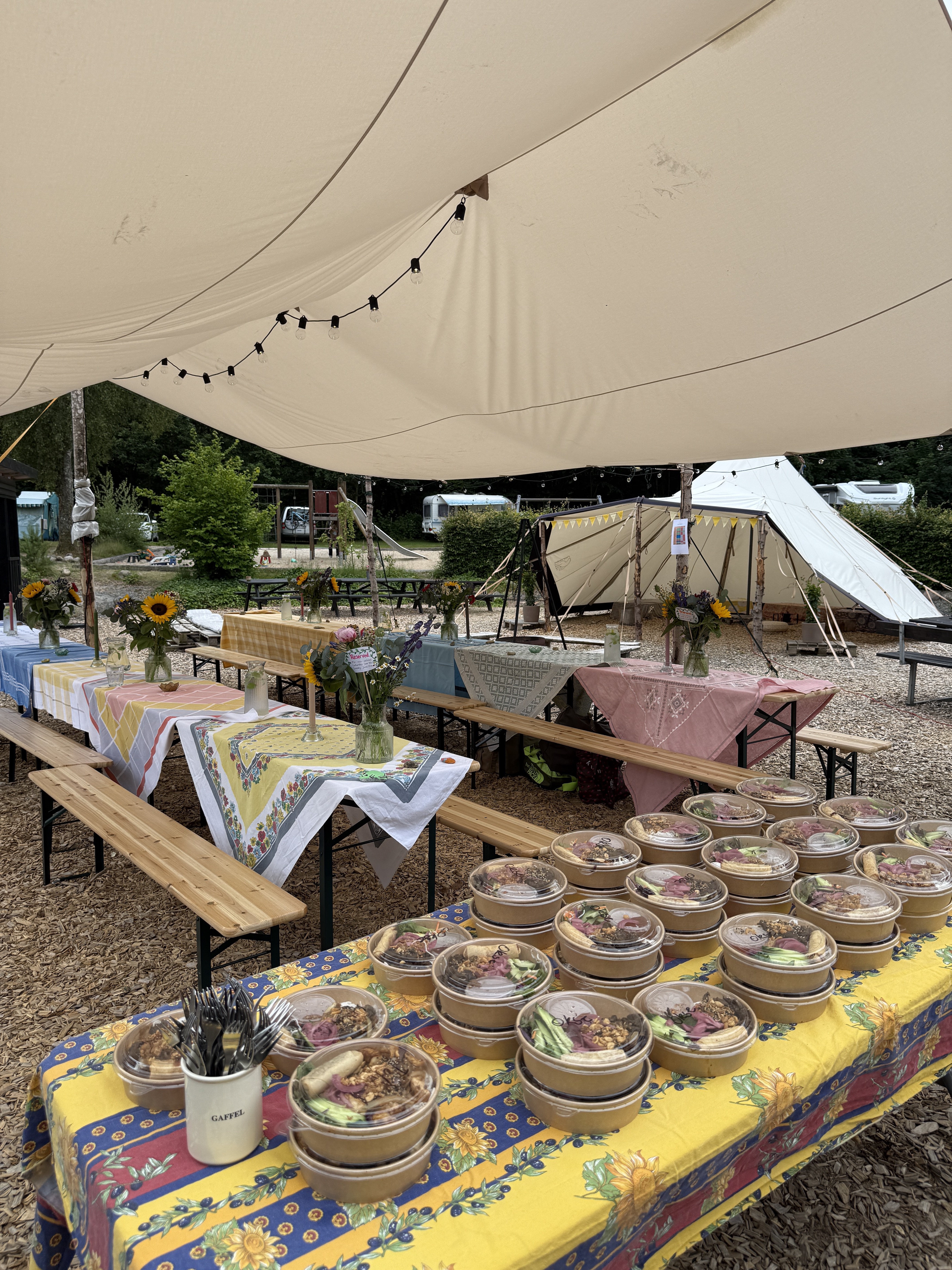 Fællespladsen dækket op til retreat-deltagere med duge og blomster.